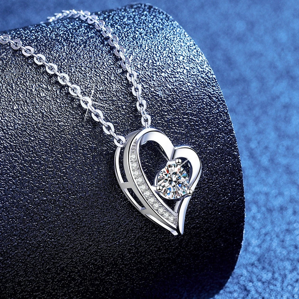 Heart Knot Moissanite Pendant Necklace with Cubic Zirconia in Platinum-Plated S925 Sterling Silver blue background angled view