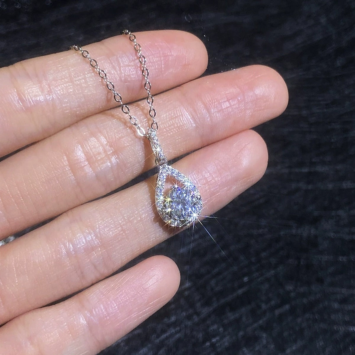 Pear Drop Moissanite Pendant Necklace with Cubic Zirconia in Platinum-Plated S925 Sterling Silver worn on neckline by model