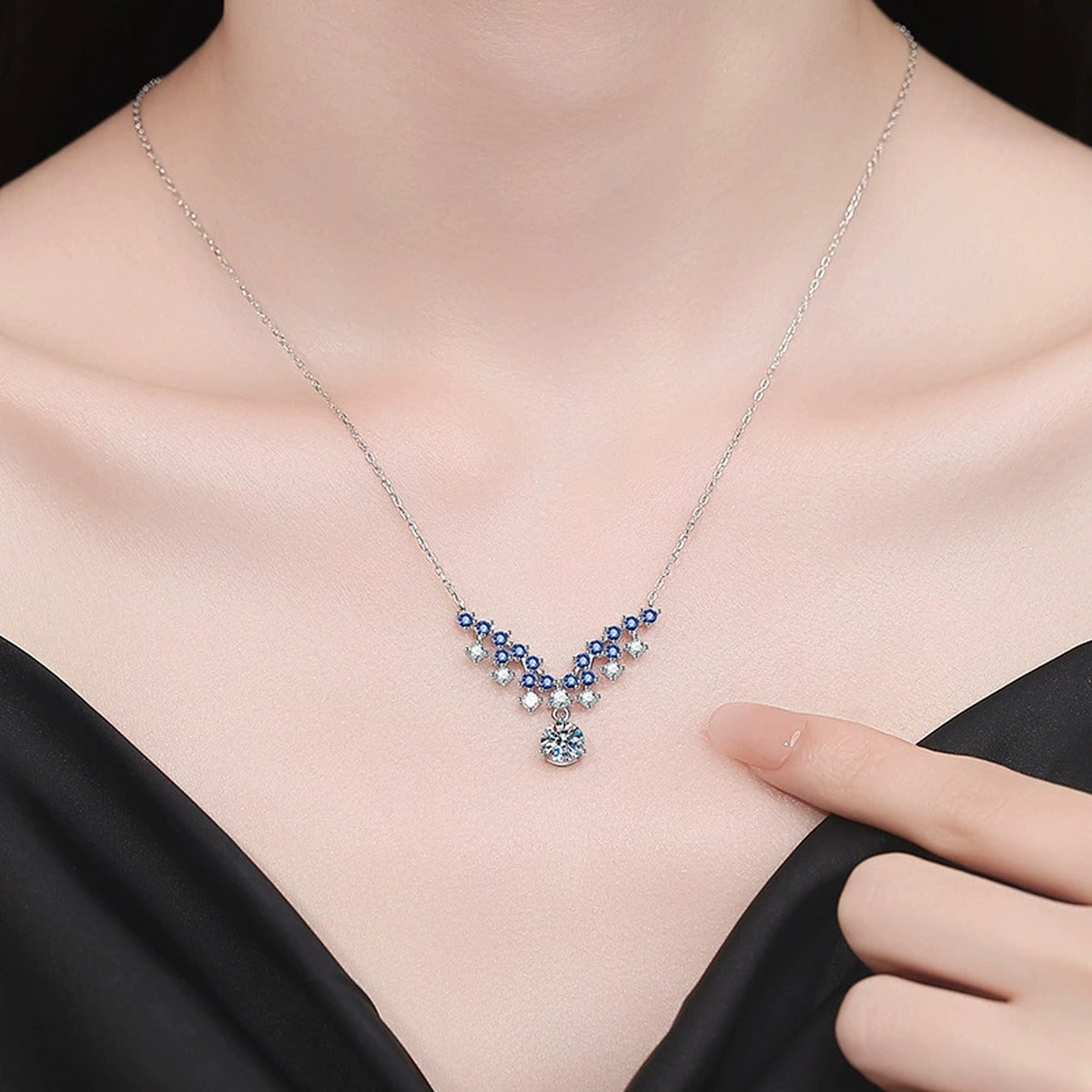 Blue Accent Graduated Moissanite Drop Necklace with Cubic Zirconia in Platinum-Plated S925 Sterling Silver worn on neckline by model
