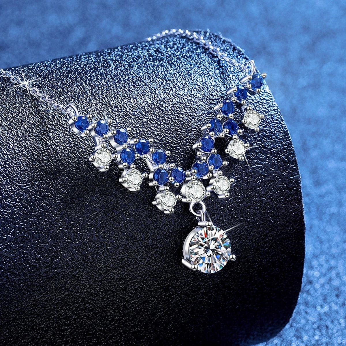 Blue Accent Graduated Moissanite Drop Necklace with Cubic Zirconia in Platinum-Plated S925 Sterling Silver blue background product view