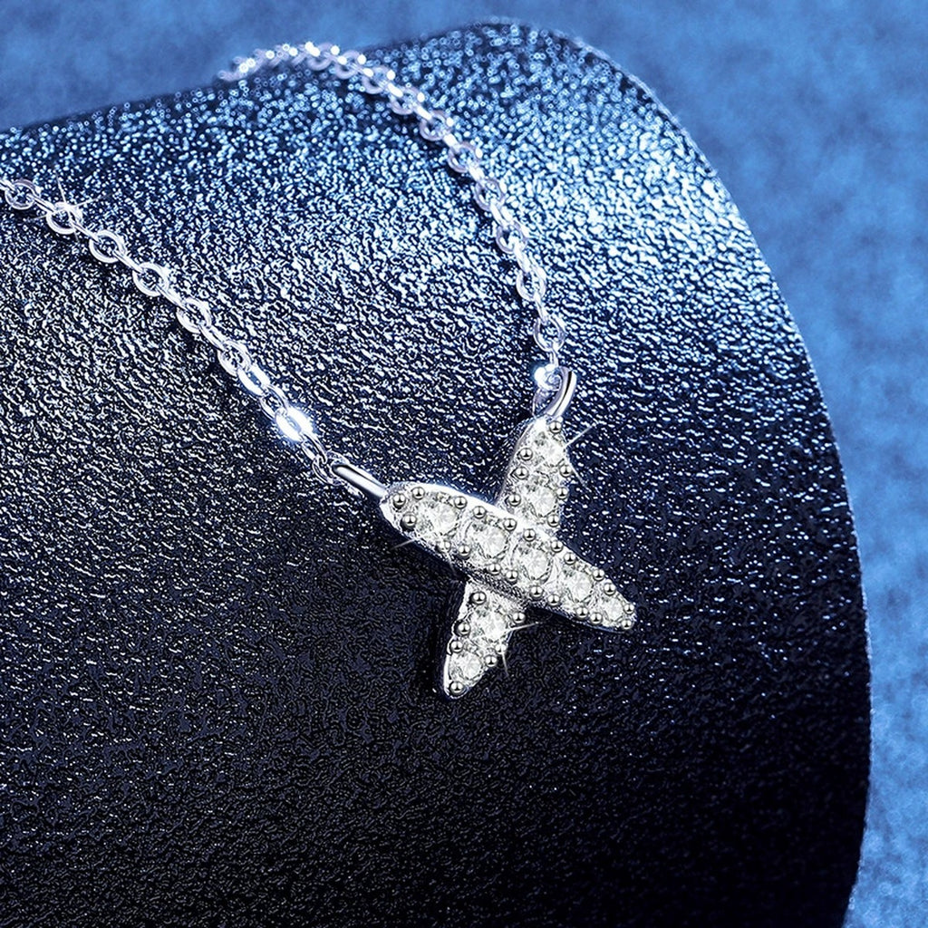 X Motif Moissanite Pendant Necklace in Platinum-Plated S925 Sterling Silver blue background angled view
