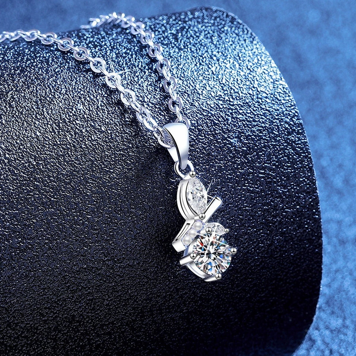 Pearl Drop Moissanite Pendant Necklace with Cubic Zirconia in Platinum-Plated S925 Sterling Silver blue background angled view