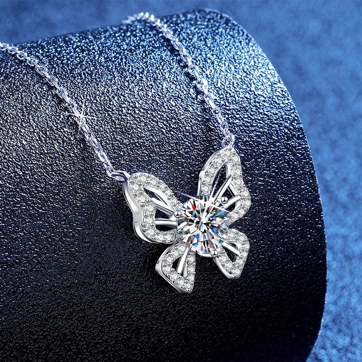 Butterfly Moissanite Pendant Necklace with Cubic Zirconia in Platinum-Plated S925 Sterling Silver blue background angled view