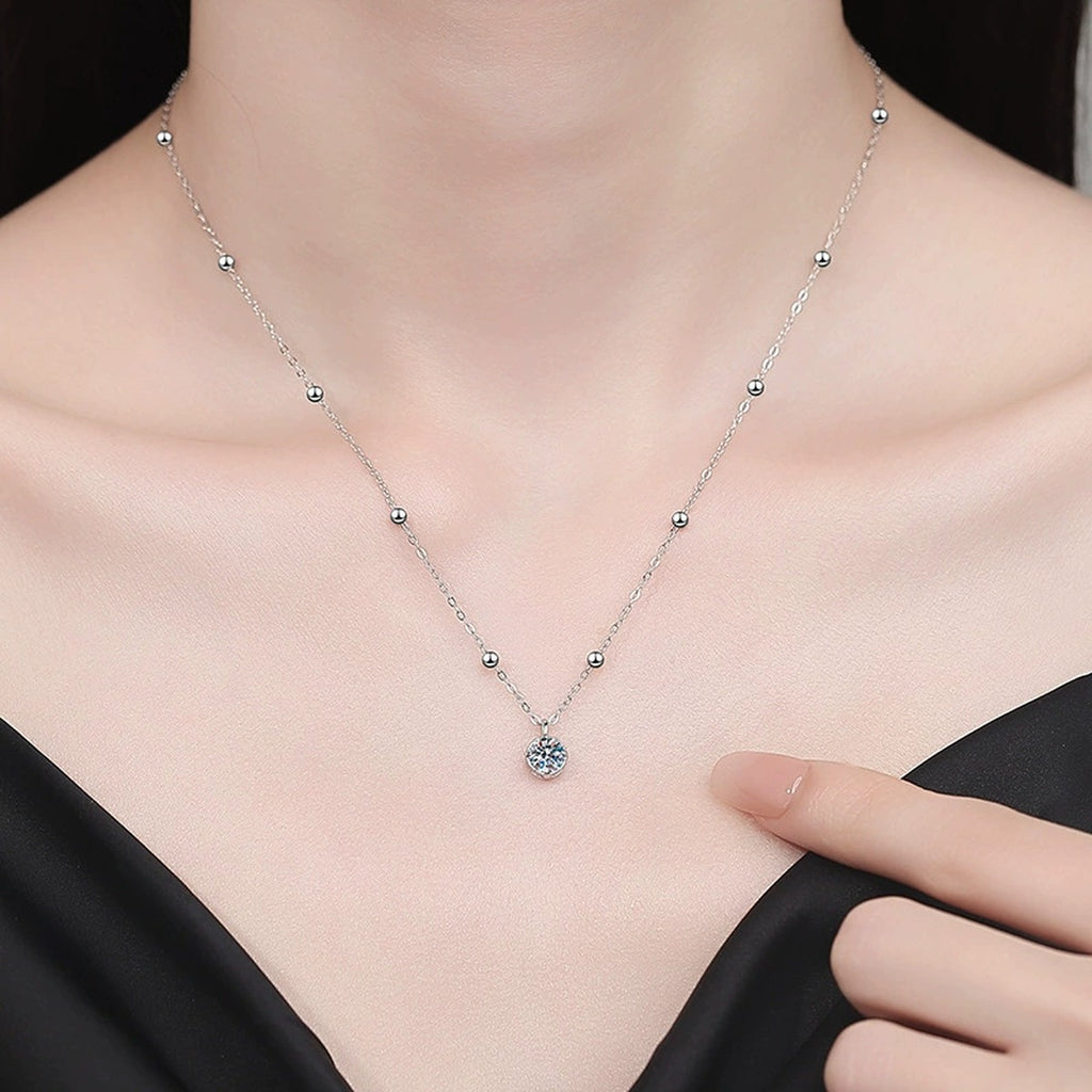Solitaire Moissanite Pendant Necklace in Platinum-Plated S925 Sterling Silver worn on neckline by model