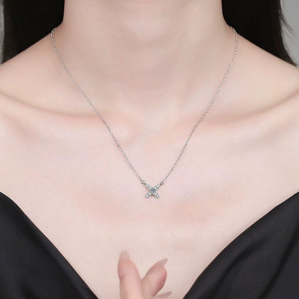 Petite X Moissanite Pendant Necklace with Cubic Zirconia in Platinum-Plated S925 Sterling Silver worn on neckline by model