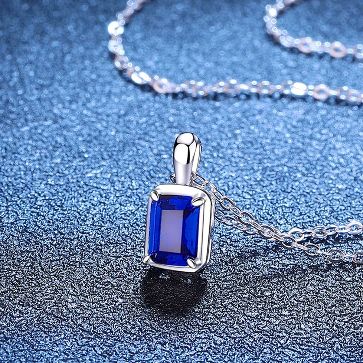 Emerald Cut Lab-Grown Gemstone and Moissanite Pendant Necklace in White Gold-Plated S925 Sterling Silver blue background styling view