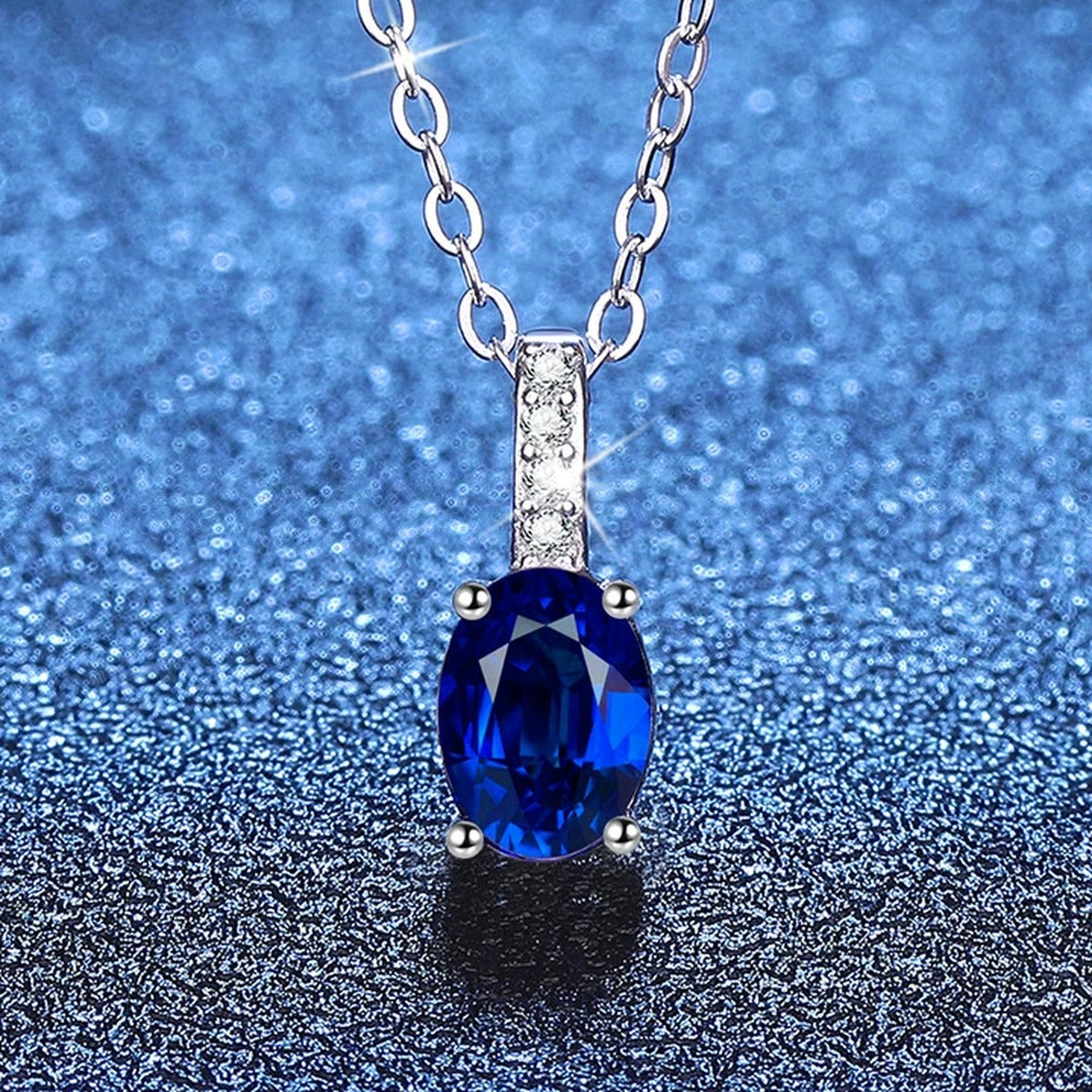 Oval Lab-Grown Gemstone and Moissanite Drop Necklace in White Gold-Plated S925 Sterling Silver blue background styling view