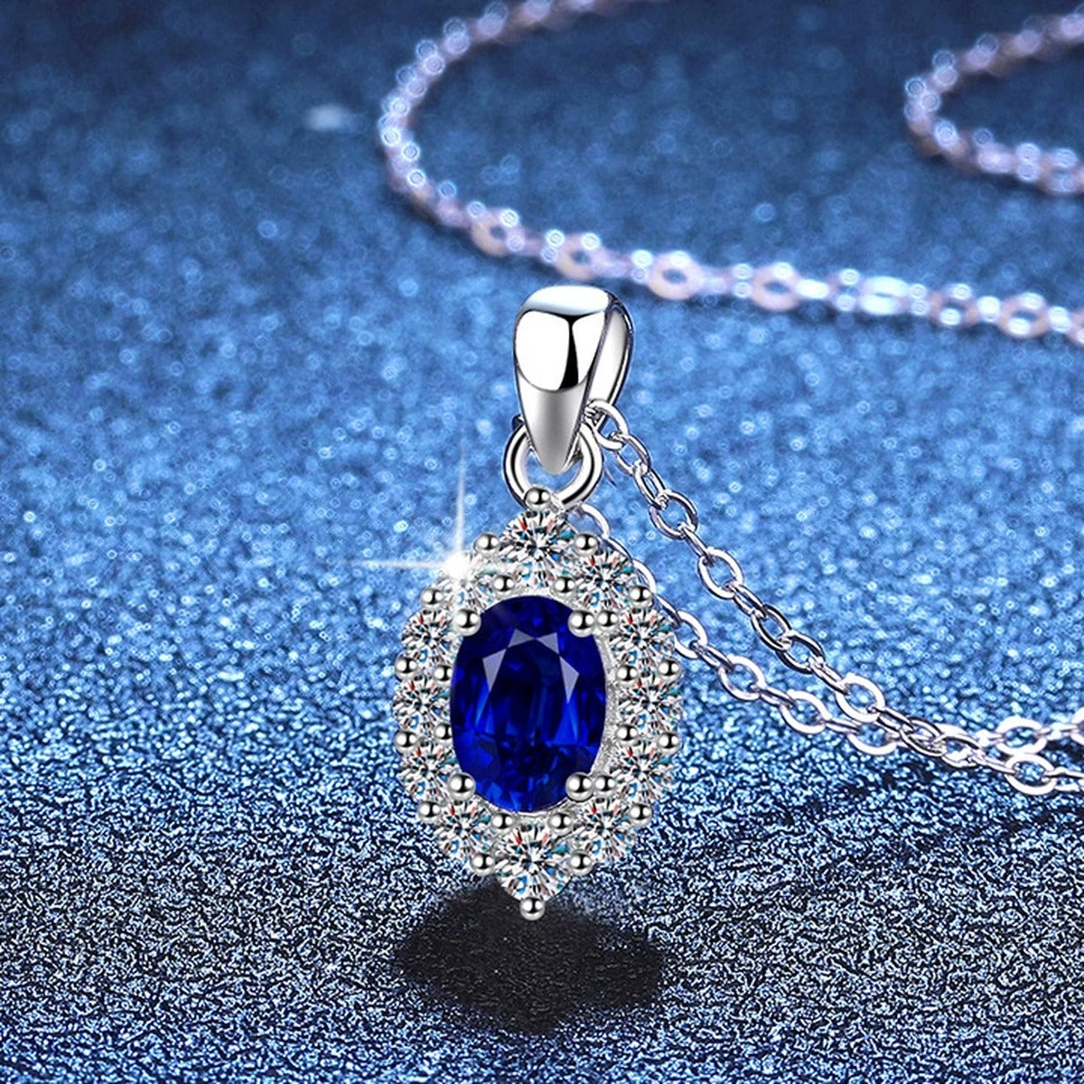 Oval Halo Lab-Grown Gemstone and Moissanite Pendant Necklace in White Gold-Plated S925 Sterling Silver blue background styling view