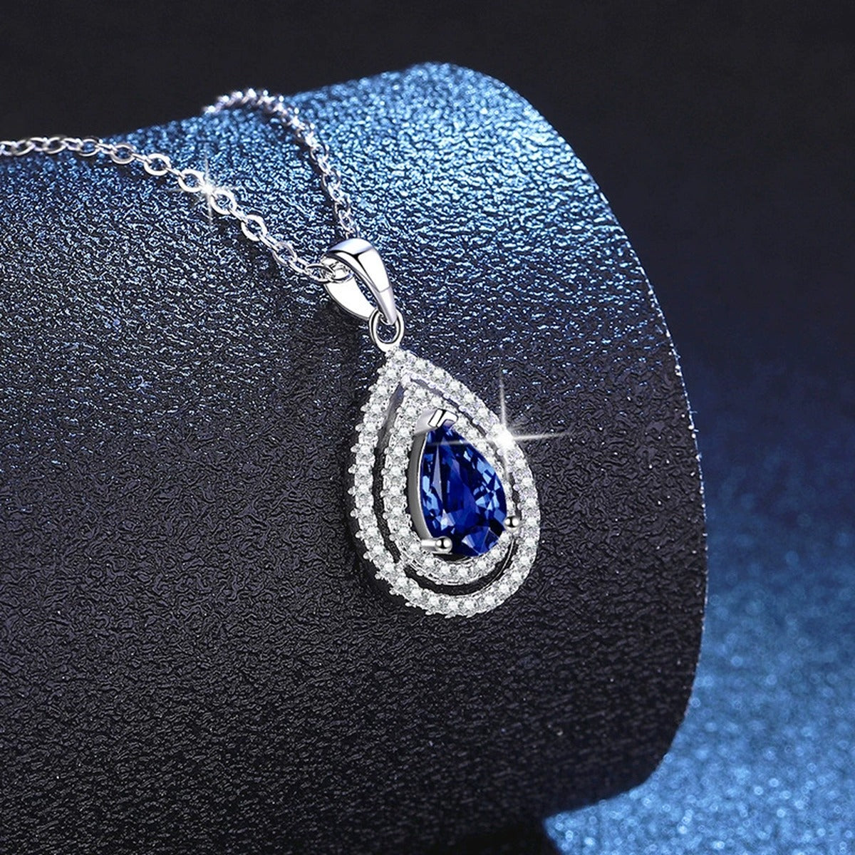 Pear Lab-Grown Gemstone and Moissanite Pendant Necklace in White Gold-Plated S925 Sterling Silver blue background angled view