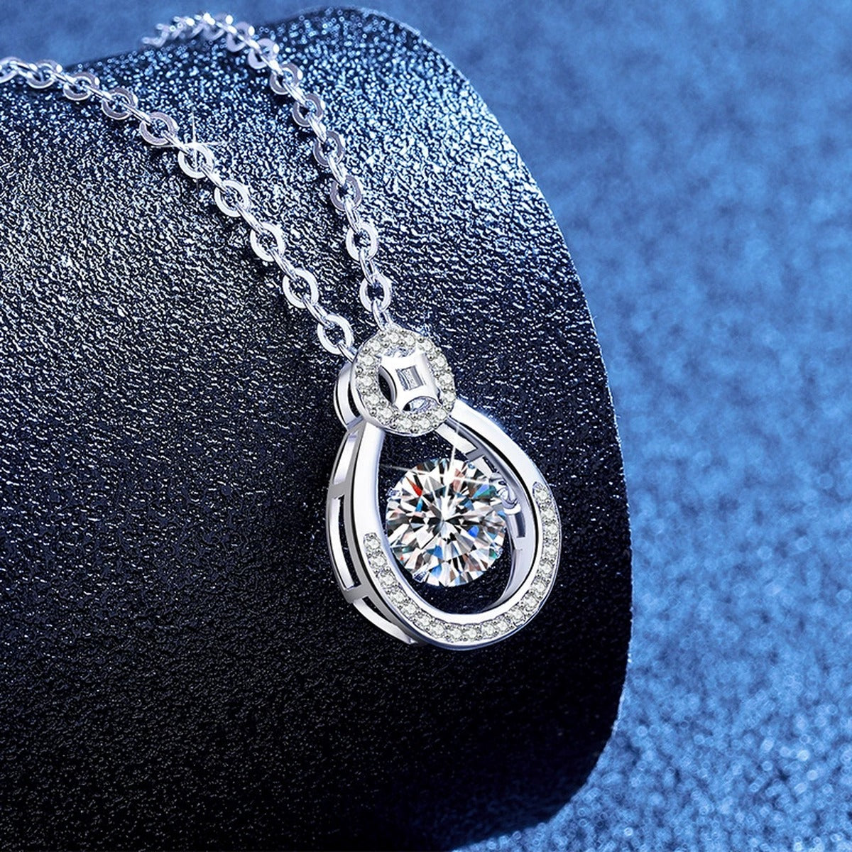 Oval Teardrop Moissanite Pendant Necklace with Cubic Zirconia in Platinum-Plated S925 Sterling Silver blue background angled view