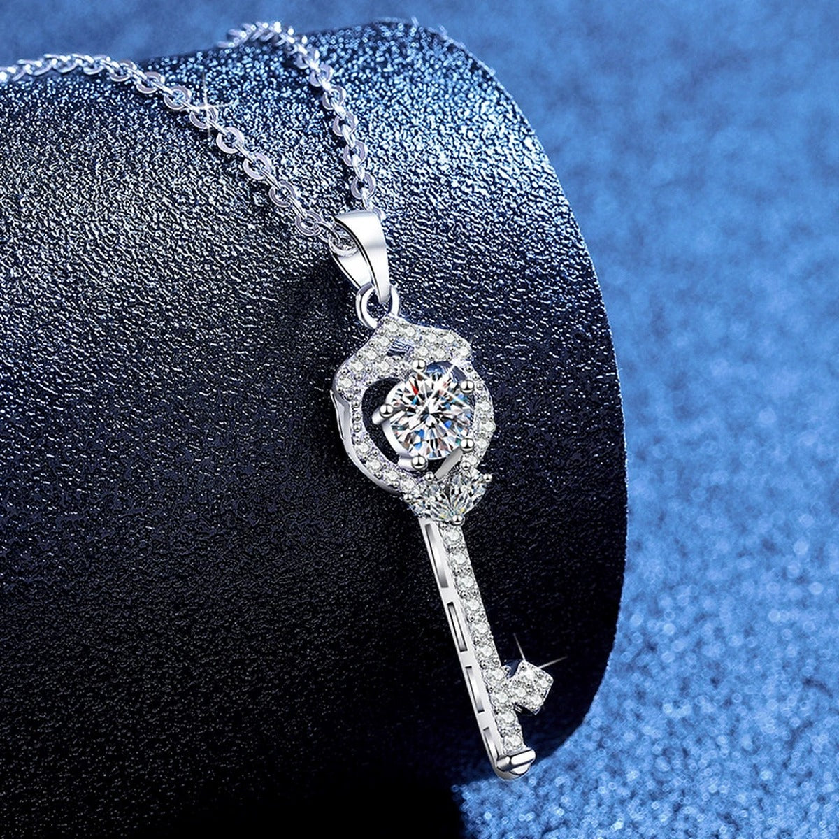 Slim Key Moissanite Pendant Necklace with Cubic Zirconia in Platinum-Plated S925 Sterling Silver blue background angled view