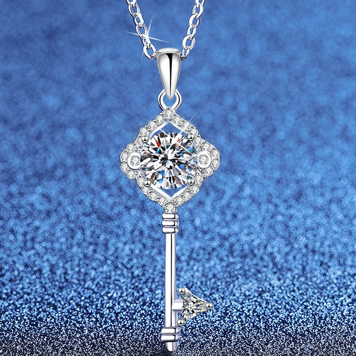 Pave Key Moissanite Pendant Necklace with Cubic Zirconia in Platinum-Plated S925 Sterling Silver blue background angled view