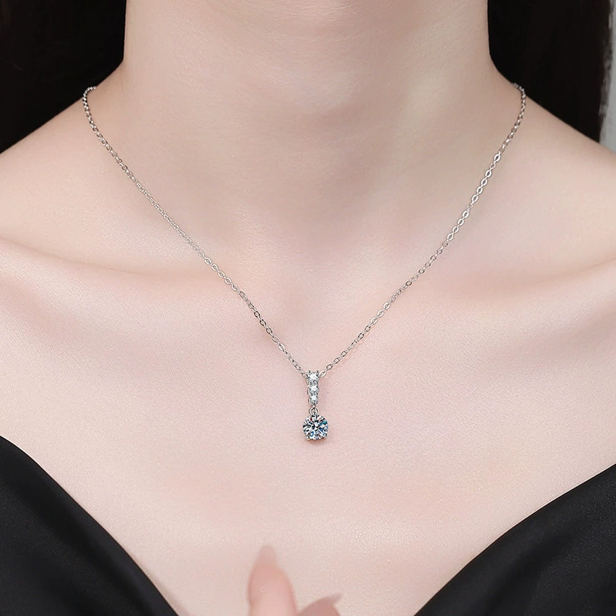 Graduated Drop Moissanite Pendant Necklace with Cubic Zirconia in Platinum-Plated S925 Sterling Silver worn on neckline by model