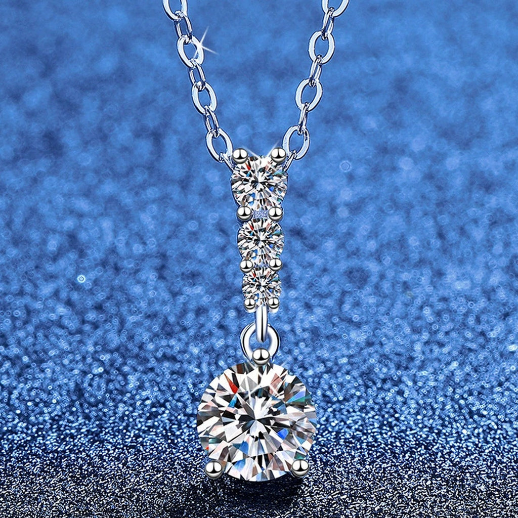 Graduated Drop Moissanite Pendant Necklace with Cubic Zirconia in Platinum-Plated S925 Sterling Silver blue background angled view