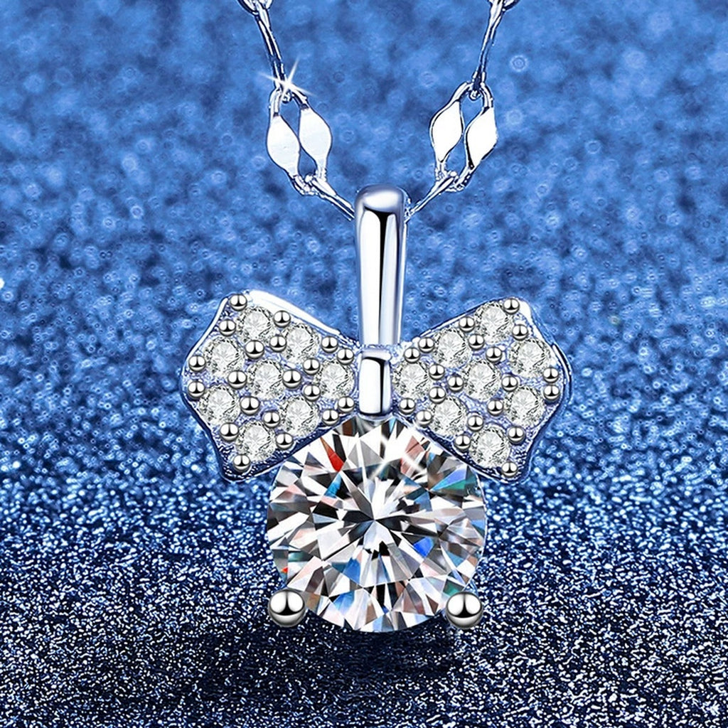 Bow Moissanite Pendant Necklace with Cubic Zirconia in Platinum-Plated S925 Sterling Silver blue background angled view