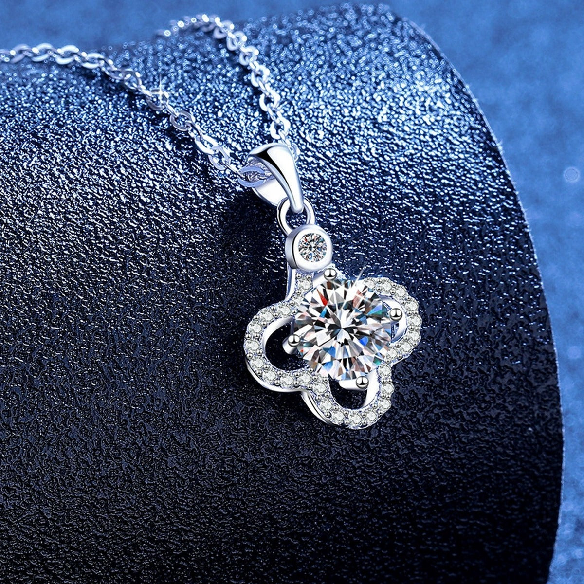 Clover Halo Moissanite Pendant Necklace with Cubic Zirconia in Platinum-Plated S925 Sterling Silver blue background angled view