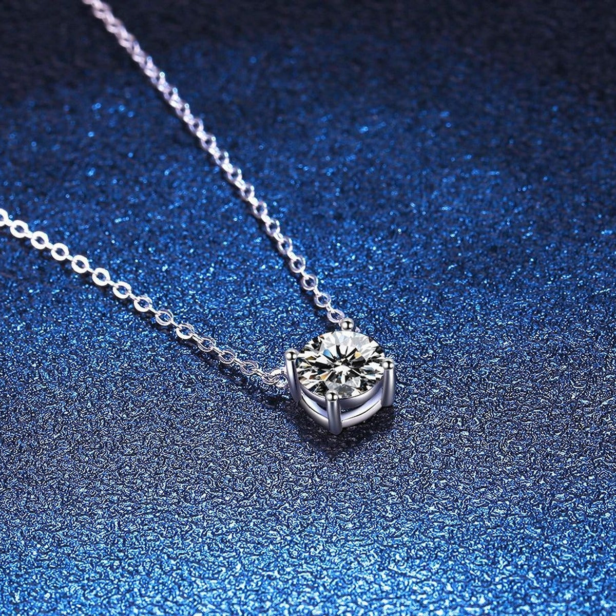 Round Moissanite Pendant Necklace in S925 Sterling Silver blue background close-up view