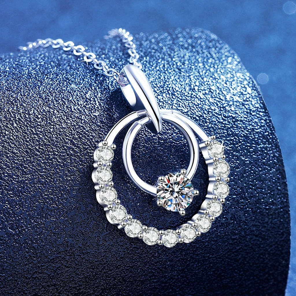 Circle Moissanite Pendant Necklace with Cubic Zirconia in White Gold-Plated S925 Sterling Silver blue background angled view