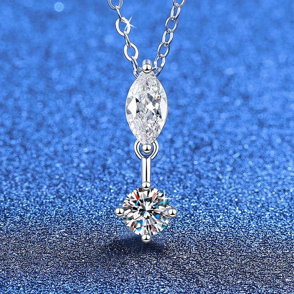 Marquise and round moissanite pendant necklace on blue textured background