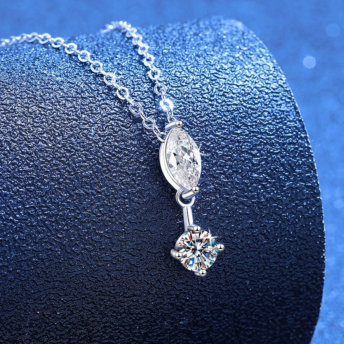Marquise and round moissanite pendant necklace styled on blue display