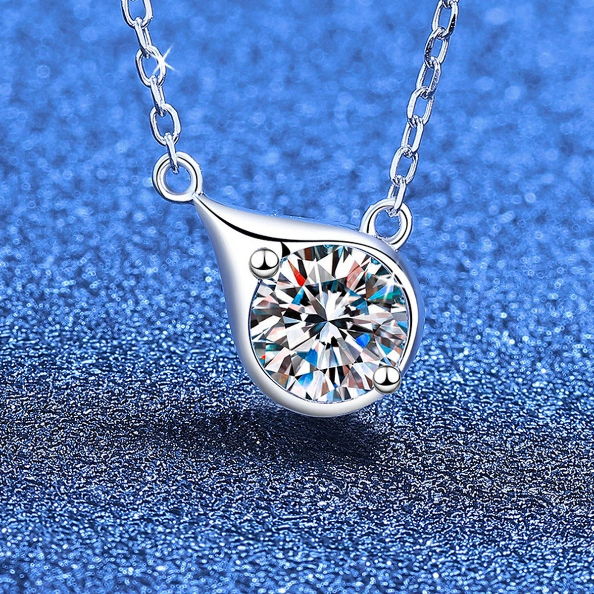Swirl round moissanite pendant necklace on blue textured background
