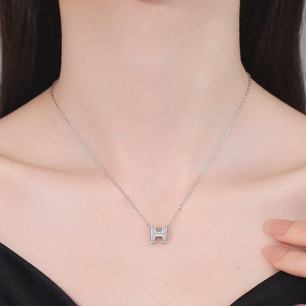 Pave Letter H Moissanite Pendant Necklace in White Gold-Plated S925 Sterling Silver worn on neckline by model