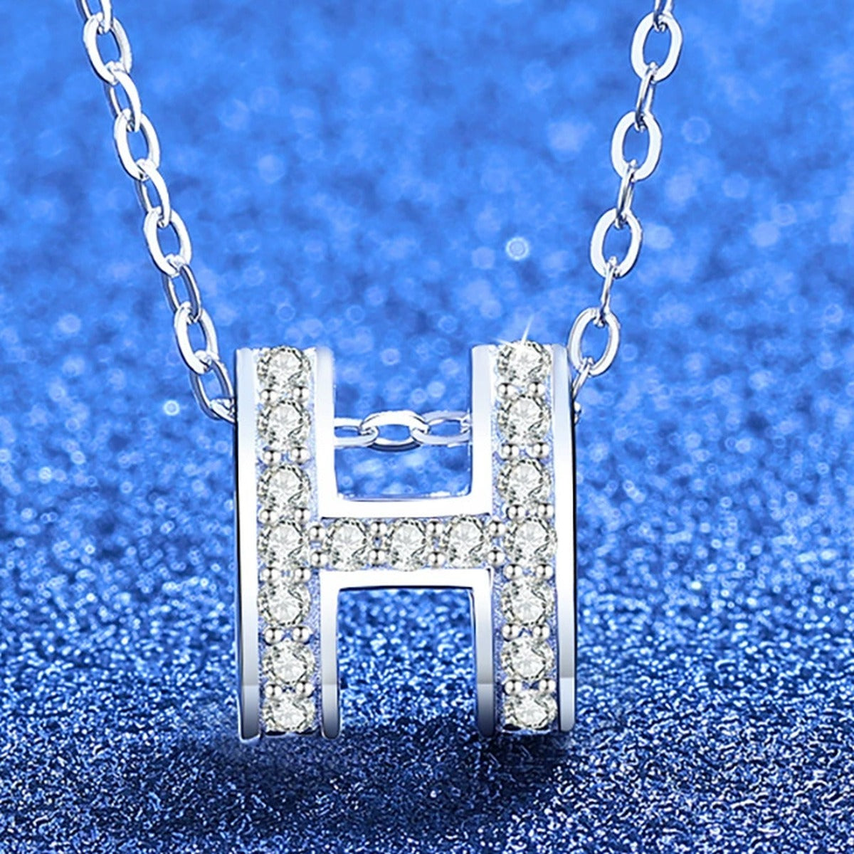 Pave Letter H Moissanite Pendant Necklace in White Gold-Plated S925 Sterling Silver blue background angled view