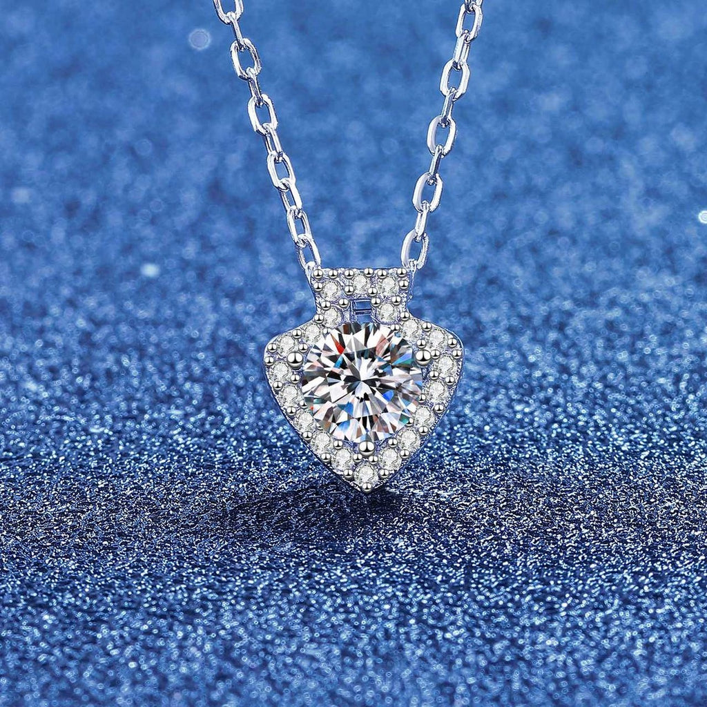 Heart round moissanite pendant necklace with pavé halo on blue textured background