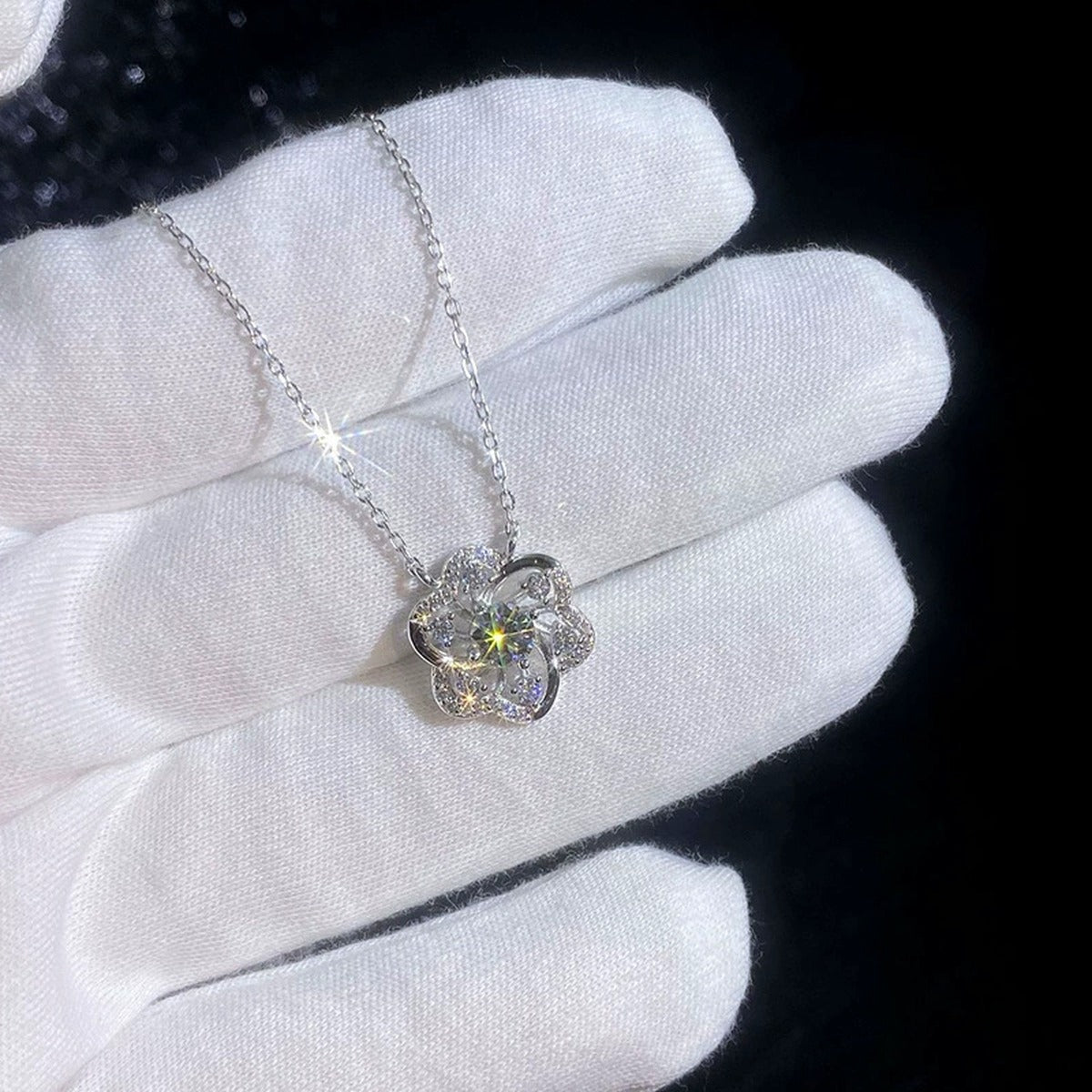Pinwheel Round Moissanite Necklace with CZ in Gold-Plated S925 sterling silver handheld close-up showing pinwheel pendant with a 0.5 ct round moissanite and CZ accents and stone setting