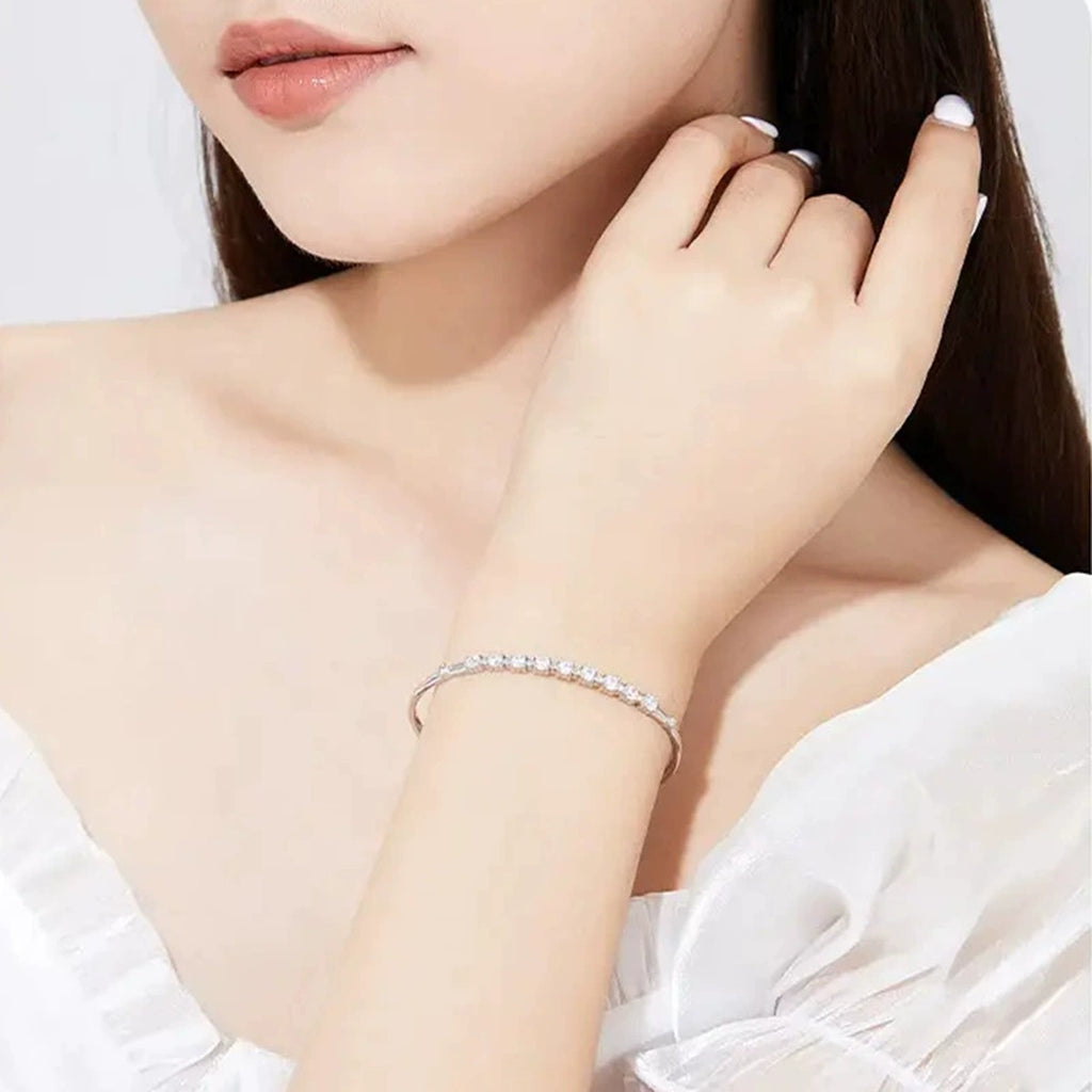 Graduated Round Moissanite Bangle Bracelet in White Gold-Plated S925 sterling silver worn on wrist model view showing scale and adjustable fit