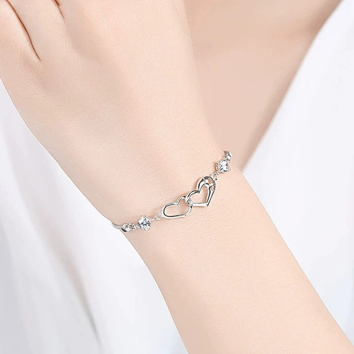 Double Heart Round Moissanite Bracelet in White Gold-Plated S925 sterling silver worn on wrist model view showing scale and adjustable fit