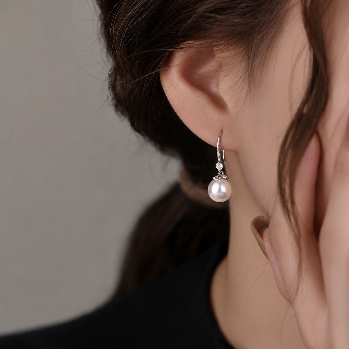 Pearl Round Moissanite Hook Dangle Earrings with CZ in White Gold-Plated S925 sterling silver worn on ear by model showing scale, placement, and hook dangle earrings styling