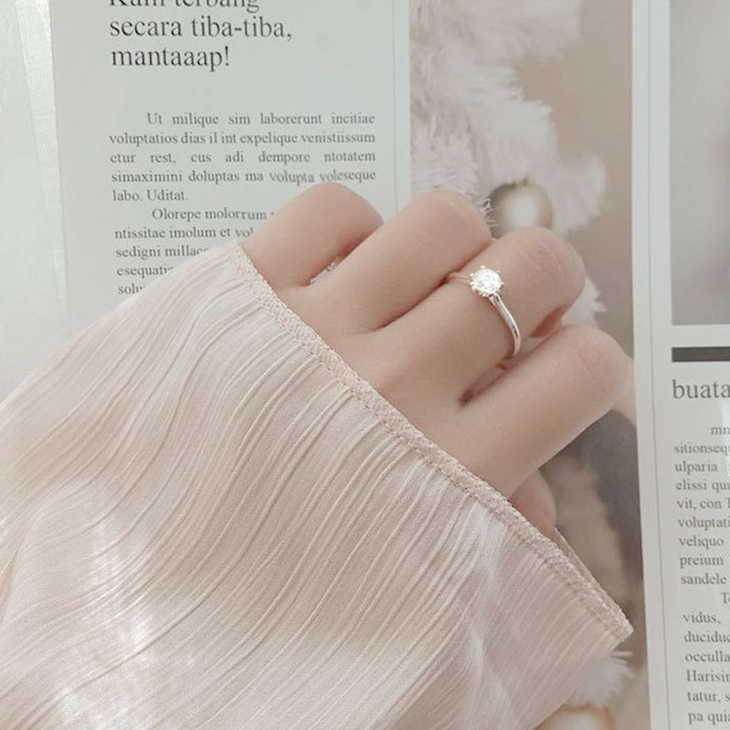 Classic Six-Prong Round Moissanite Solitaire Engagement Ring worn on hand to show scale, band width, and ring profile